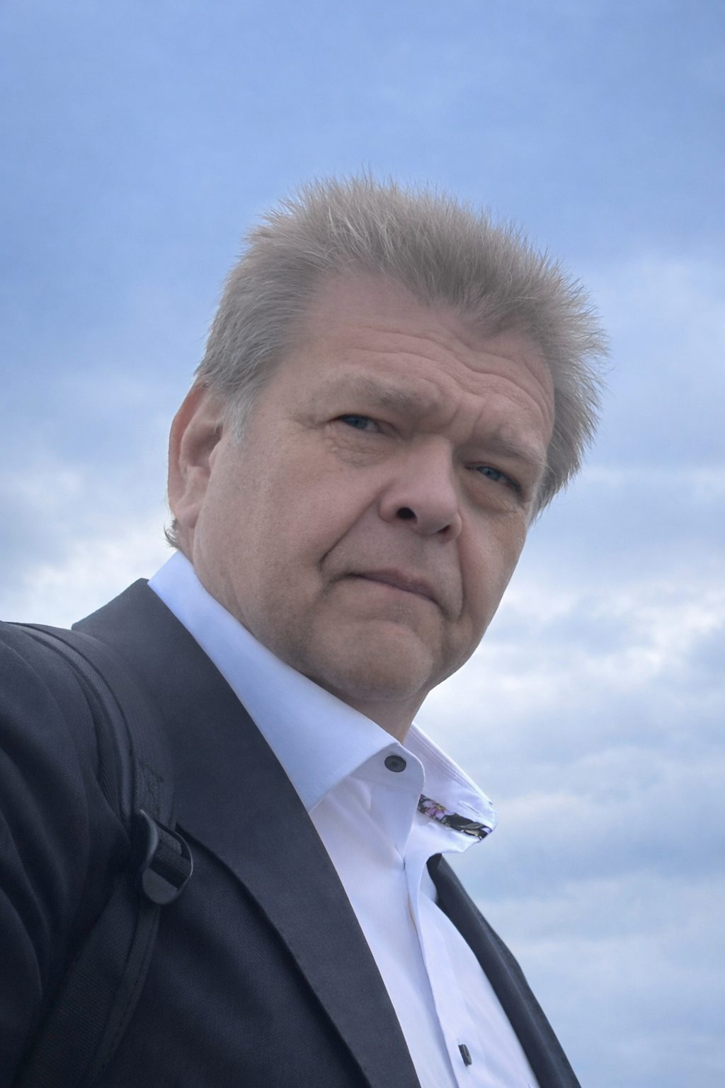 Petri Koivula in potrait, cloudy sky in the background.