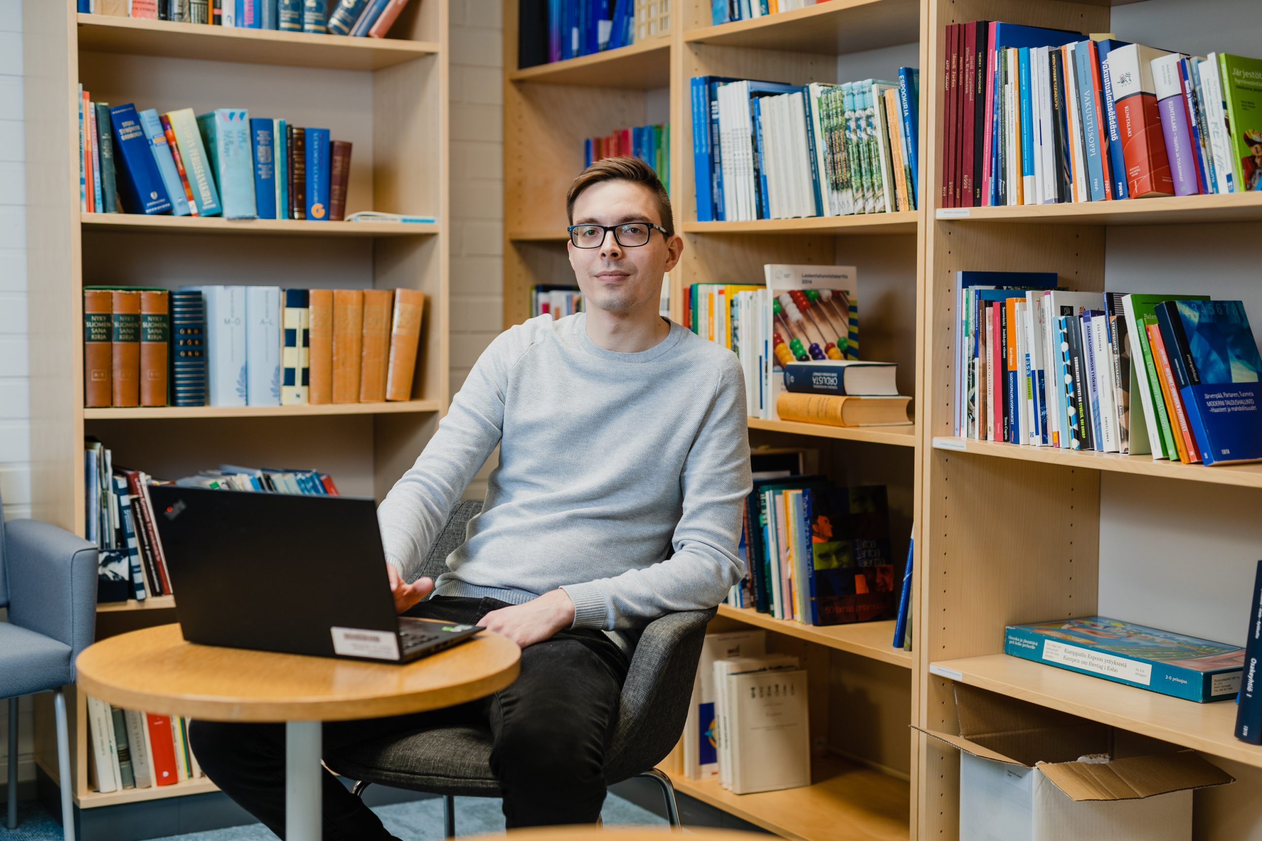 Joni Mäkinen seated in a library room.